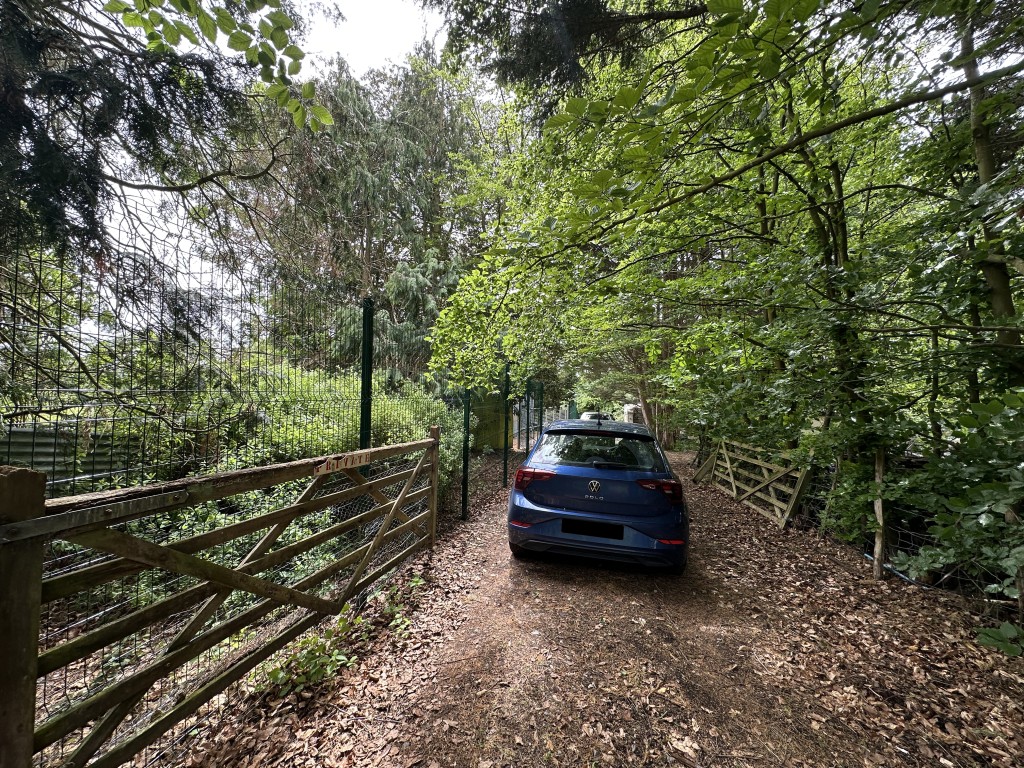 Lot: 60 - TIN BARN WITH POND SET IN APPROXIMATELY ONE ACRE - Photo of gated entrance to site